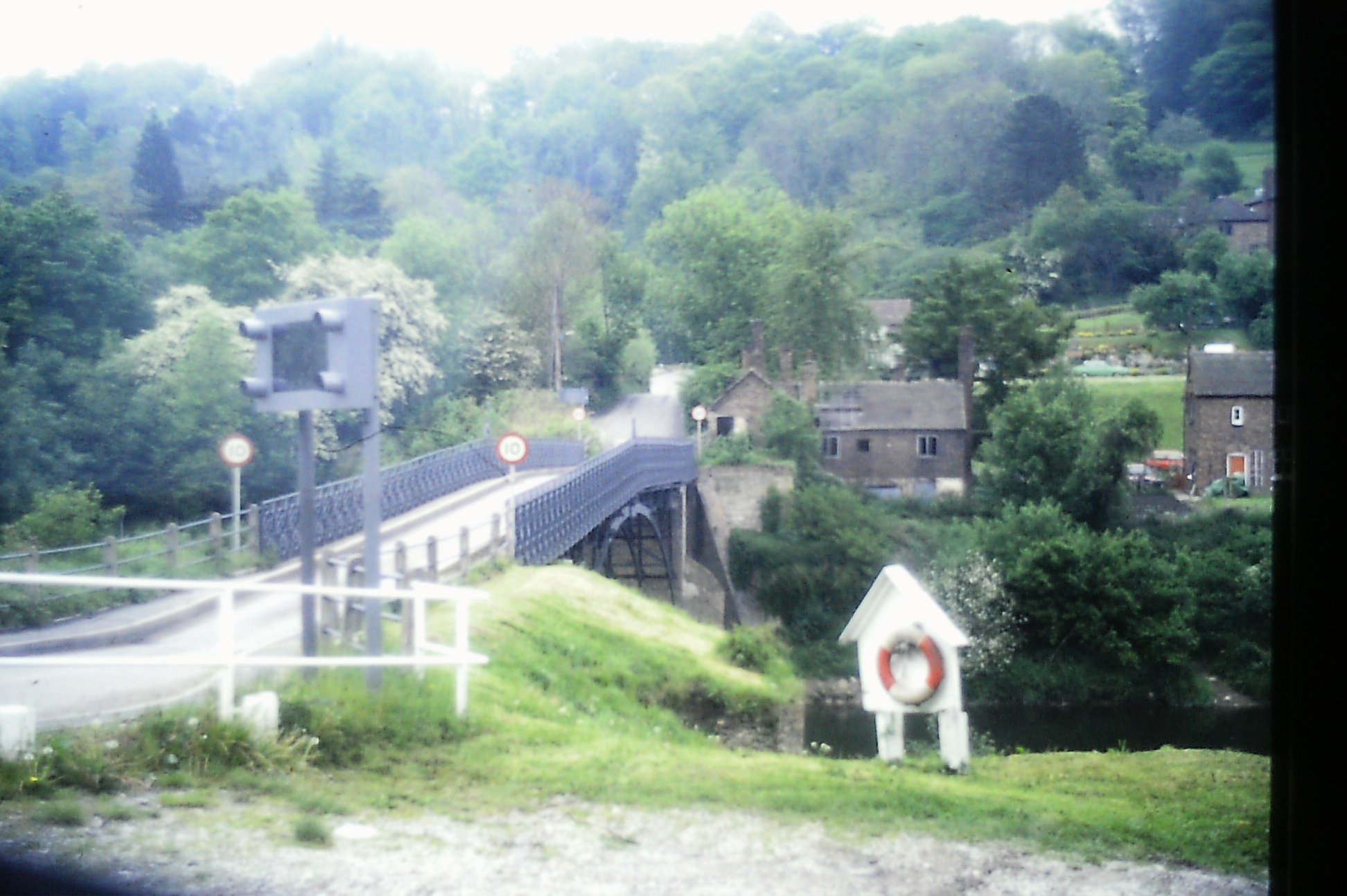 The bridge and its lifebelt post, seen from the Coalport approach sometime in the 1970s. Traffic here still looks light and unhurried in this decade — a quieter era before HGV routing turned the weight limit into the daily headache it later became for residents and council alike.