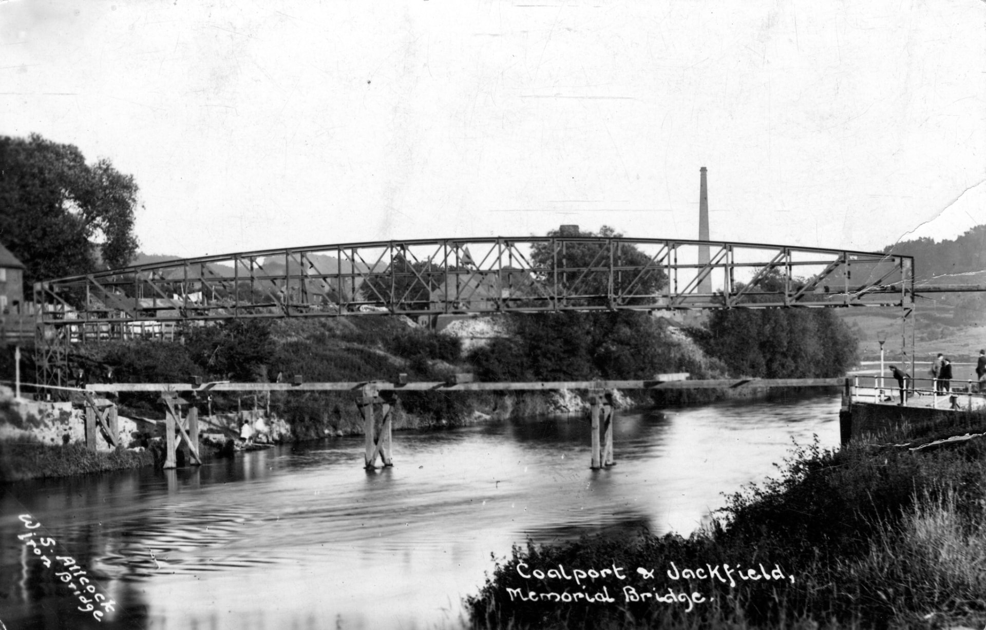 The completed bridge, with a works chimney behind and the remains of the old ferry landing in the foreground.