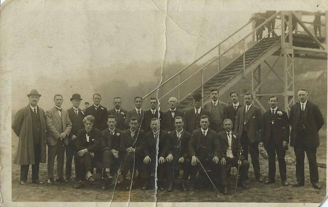The bridge committee and subscribers photographed on the Jackfield shore beneath the new steps, 1922. The stair and lamp standard behind them were part of the original approach.