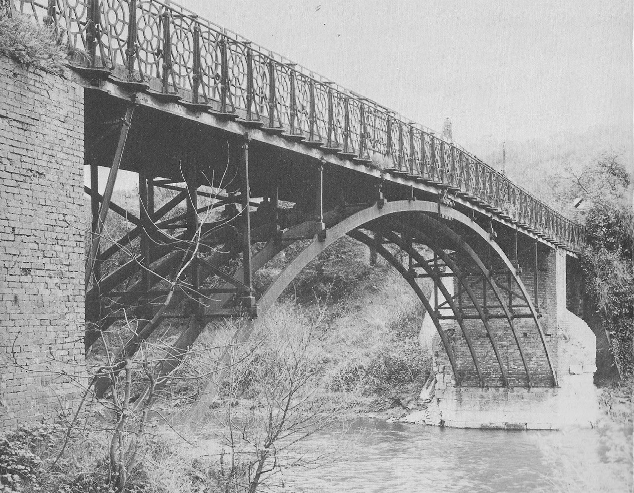 This twentieth-century photograph focuses on the point where the arch springs from its brick abutment, the lattice parapet visible above. It's worth pausing on that junction of brick and iron: it is the oldest surviving fabric on the site, dating back to the timber bridge first built here in 1780.
