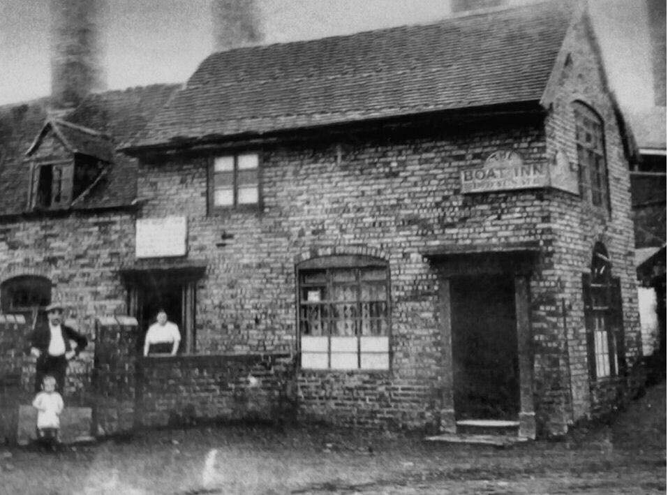 The Boat Inn, Jackfield, in its industrial days, with a family standing outside and works chimneys behind the roof.