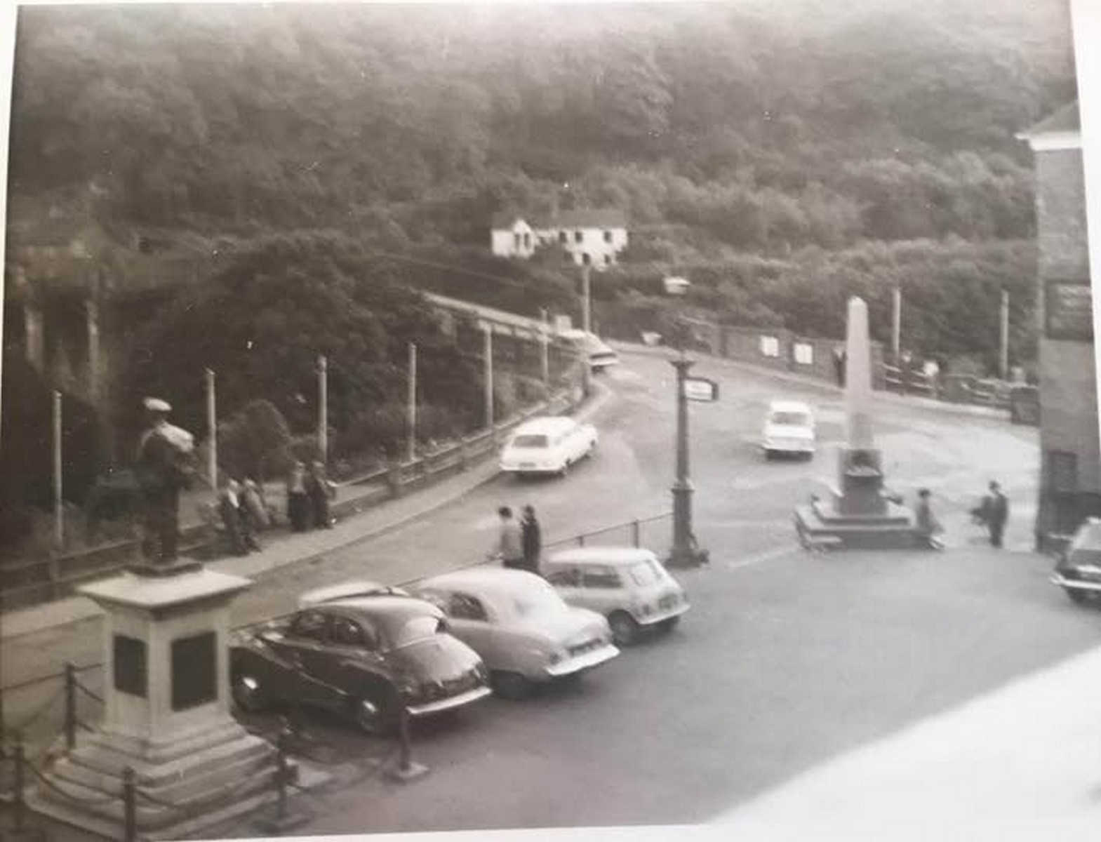 The Square in its bus-station years, saloon cars nosed in around the obelisk. This was the moment the space changed job: from a place where people stopped and traded to a place where vehicles waited. The 1950s and 60s did that to a great many market towns.