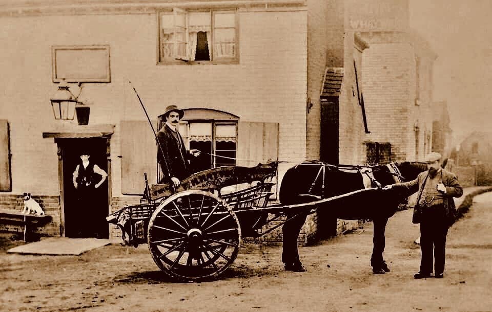 The Meadow Inn in its working days, with a horse and cart outside and the landlady standing in the doorway.