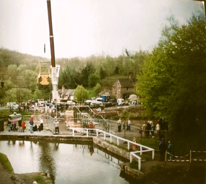 28 April 2000: the refurbished span being lowered back onto its abutments, watched from both banks.