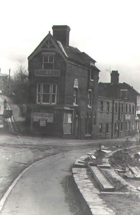 The corner building with boarded windows and roadworks in the foreground