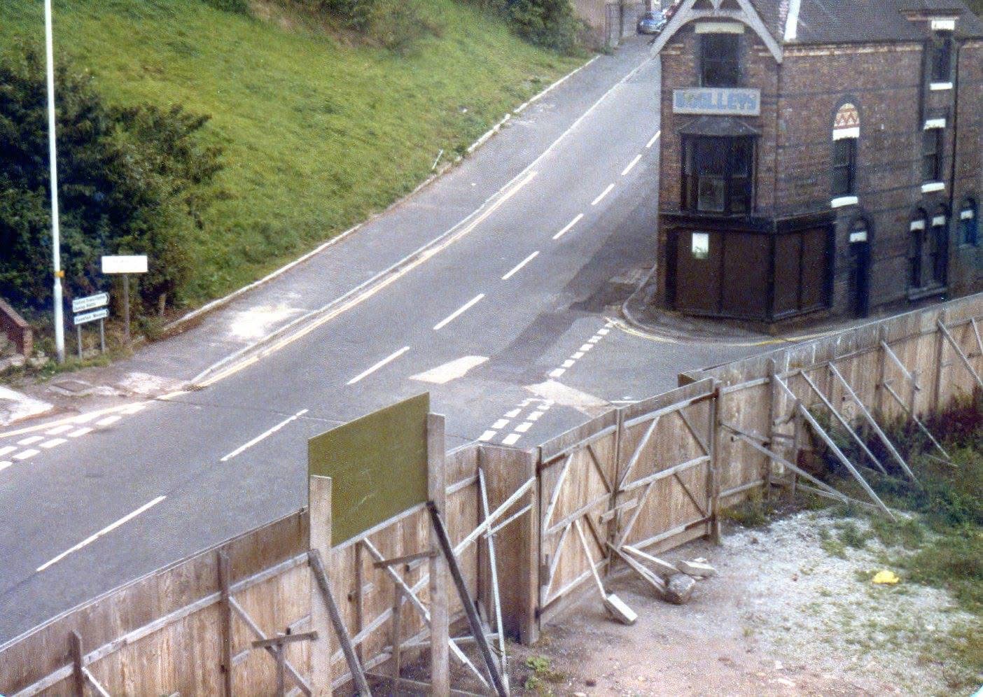 The Waterloo Street / Madeley Hill junction from above, with a timber retaining wall under construction beside the road