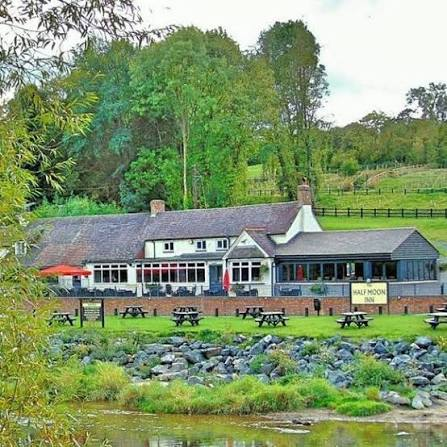 The Half Moon Inn today, beside the River Severn at Jackfield, with its riverside garden and the Half Moon Inn sign.