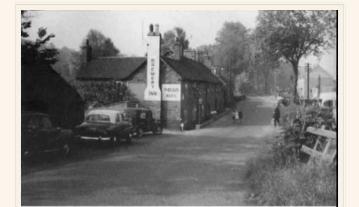 The Brewery Inn, Coalport, with its painted gable signs and vintage cars parked outside.