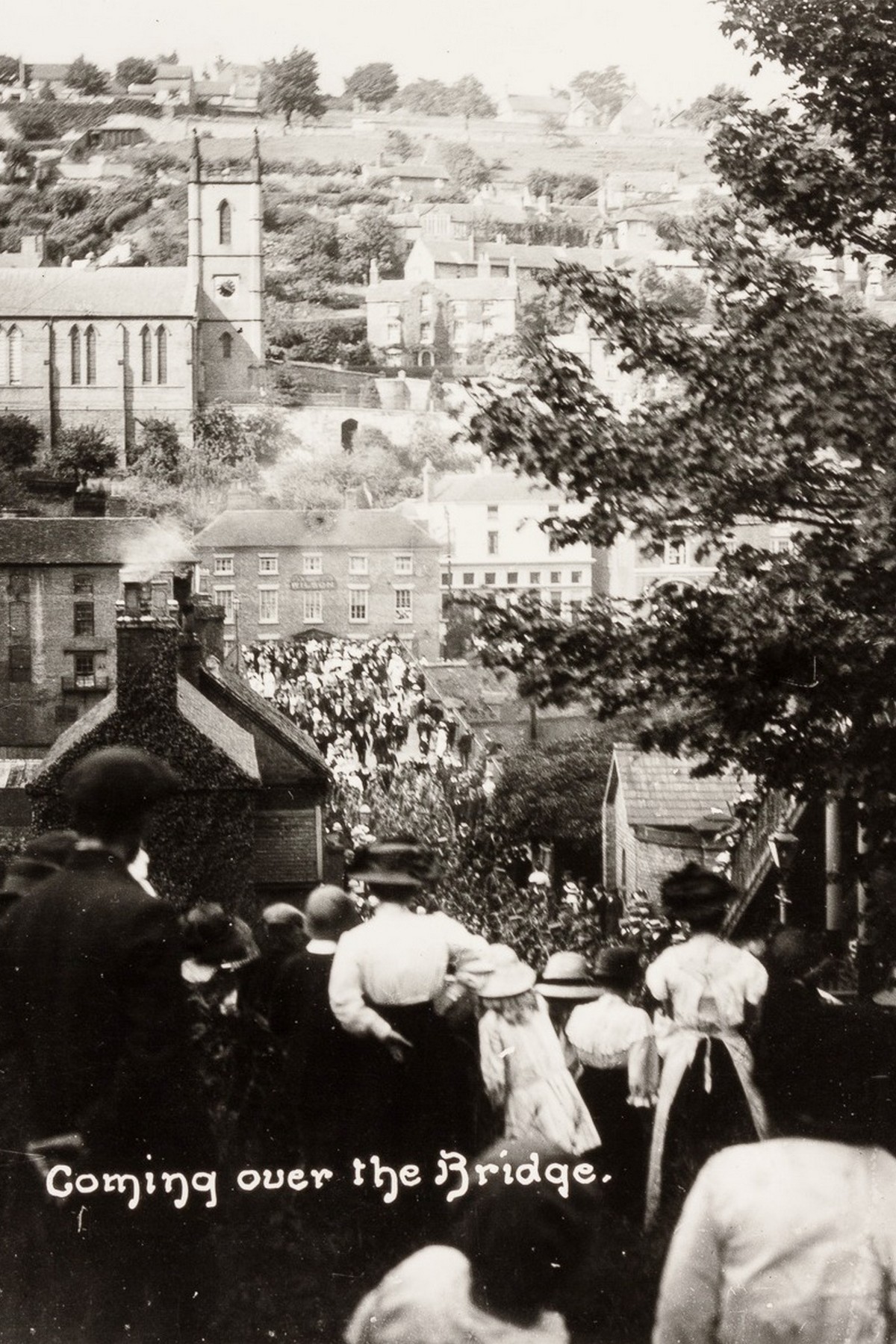 Captioned “Coming over the Bridge,” this photograph shows the crowd streaming across the Iron Bridge and down towards the station to see the men of Ironbridge off to war. Many of those being seen off would never come back to cross the bridge again. The number of people in the road tells you what the day meant to the town.