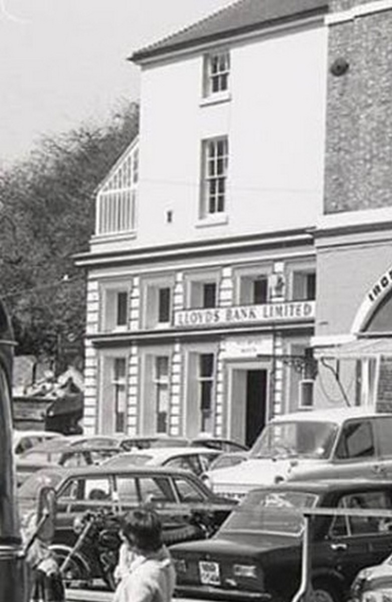 Lloyds Bank Limited on the Square, cars packed nose-in along the frontage. A branch bank here says a good deal about the town's confidence: money, as well as market produce, changed hands in this corner of Ironbridge. Exact date unknown.