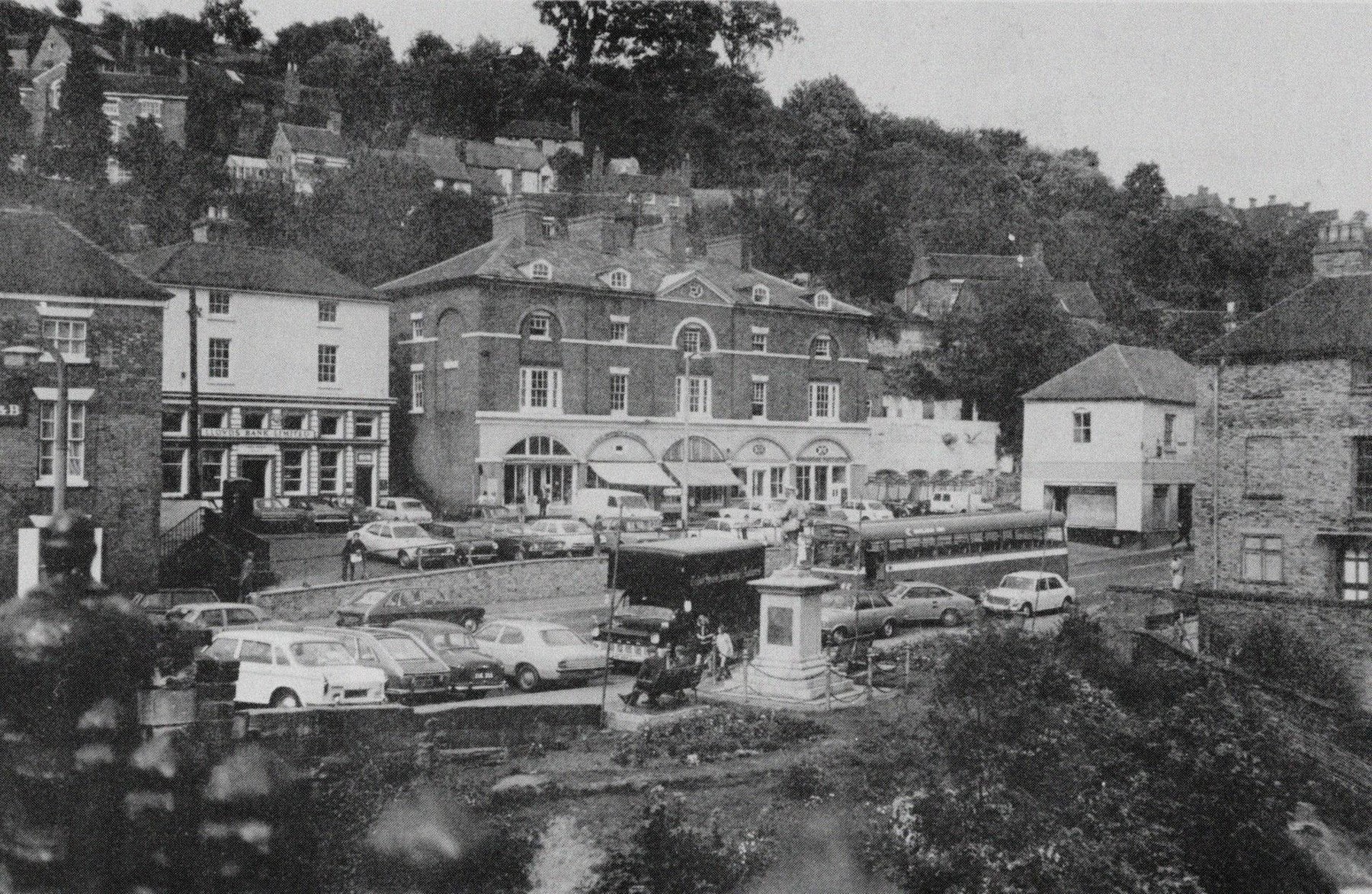 The Square seen from above in the 1970s, coaches at the terminus and every spare yard given over to parking. From this angle the loss is obvious — the open market ground has vanished under vehicles, and the case for change makes itself.