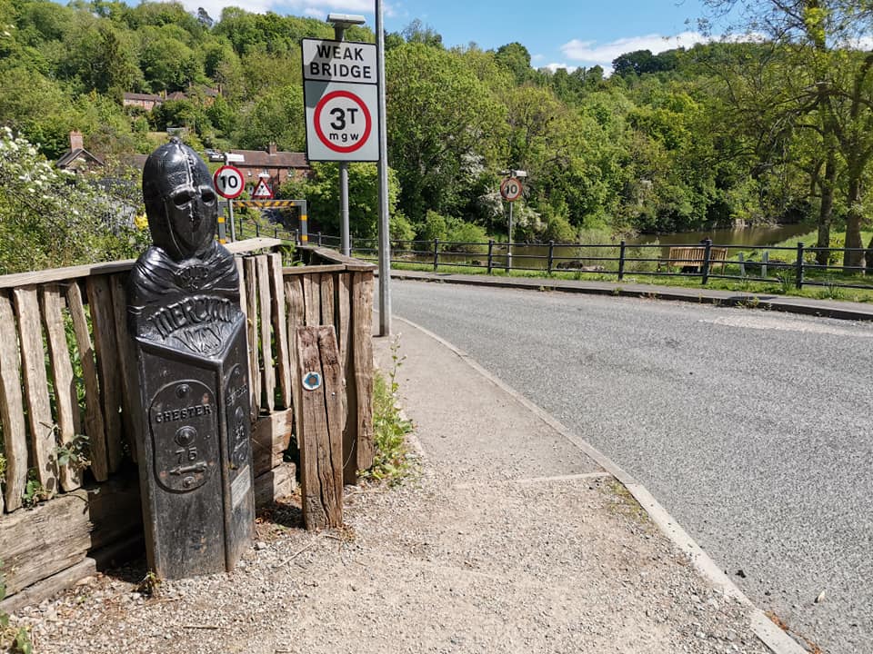 A modern “weak bridge — 3T mgw” sign stands beside the old cast-iron milepost, two very different eras of roadside information side by side. The current limit restricts crossings to three tonnes maximum gross weight, and only one vehicle at a time — a strict regime that keeps the Georgian ironwork in daily use.