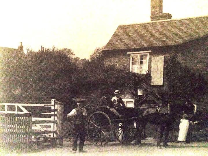 A horse and trap pauses at the gate beside the toll house in this early-1900s photograph. Every cart that passed here paid its due — sixpence to a shilling depending on how many horses were in the shafts — a system of tolls that funded the bridge's upkeep for well over a century.
