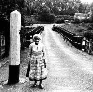 Mrs Green, the toll house's mid-twentieth-century shopkeeper, photographed standing on the bridge deck. Look at how ordinary the scene feels — for many locals of this era the building wasn't remembered as a historic toll collector's office at all, but simply as “Mrs Green's”, the corner shop everyone knew.