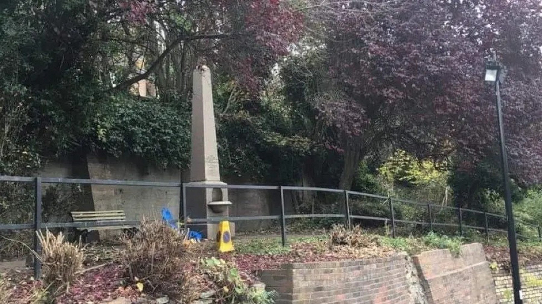 The fountain today, railed off above the Waterloo Street car park. It stands a little apart now, easy to walk past without noticing, yet it is the same monument that once presided over market day. Look for the worn stonework at its base. Present day.