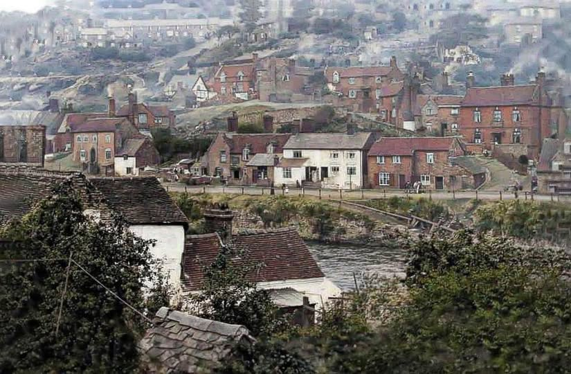 The same rise of buildings above the river in a later colourised view, cottages and rooftops stepped up the hillside