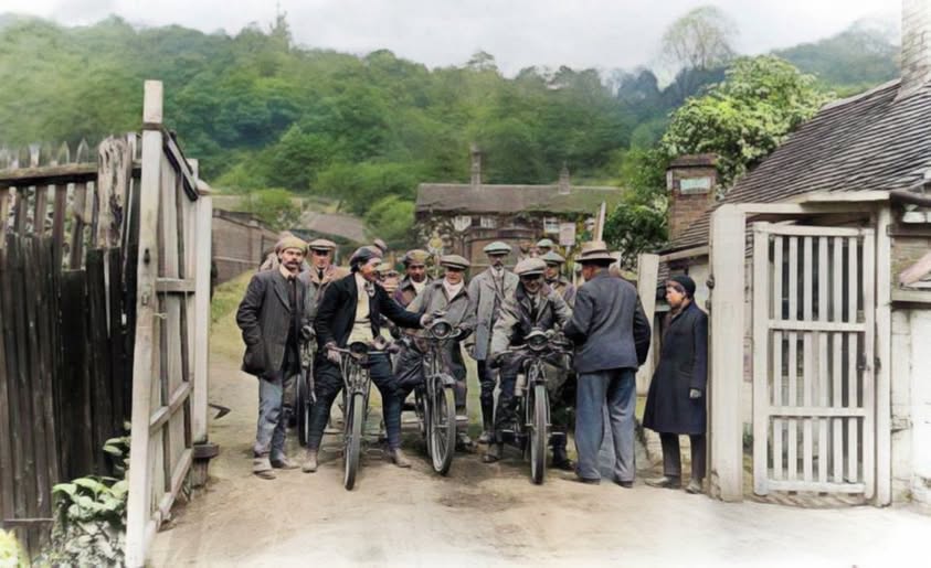 Competitors and officials gather at the toll gate before the May 1911 hill climb begins. Look past the riders to the gate itself, swung open for the day: this is one of the clearest surviving photographs of the toll gate actually in working use, a detail easy to miss amid all the motorcycling excitement.